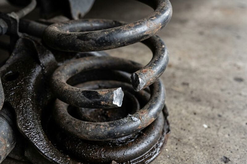 Why do rear coil springs break in cold weather on some models (like the Mazda 3 BL)?